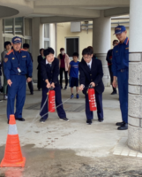 消防士さんからの話を聞き、水消火器による消火体験をする生徒