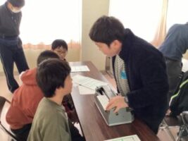 点字体験で藤ノ木小学校の児童に点字で名前を書いてあげている児童